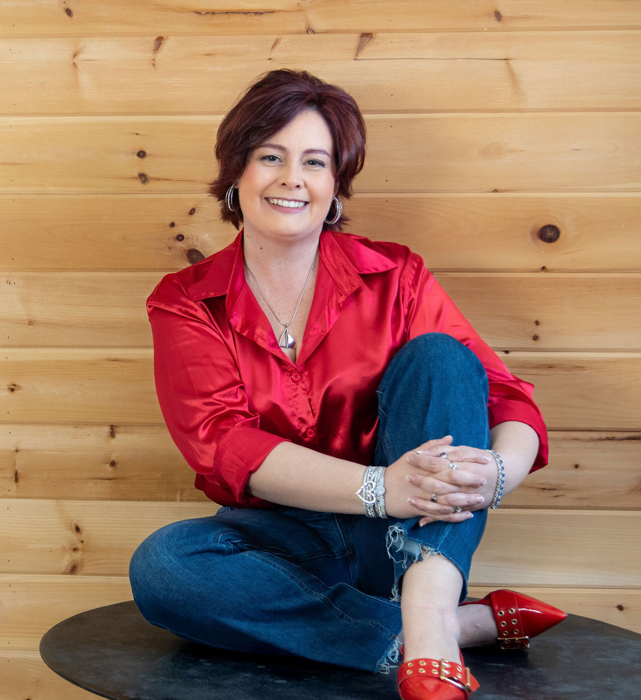 Melanie Rhora, women's empowerment speaker, seated and gesturing upward
